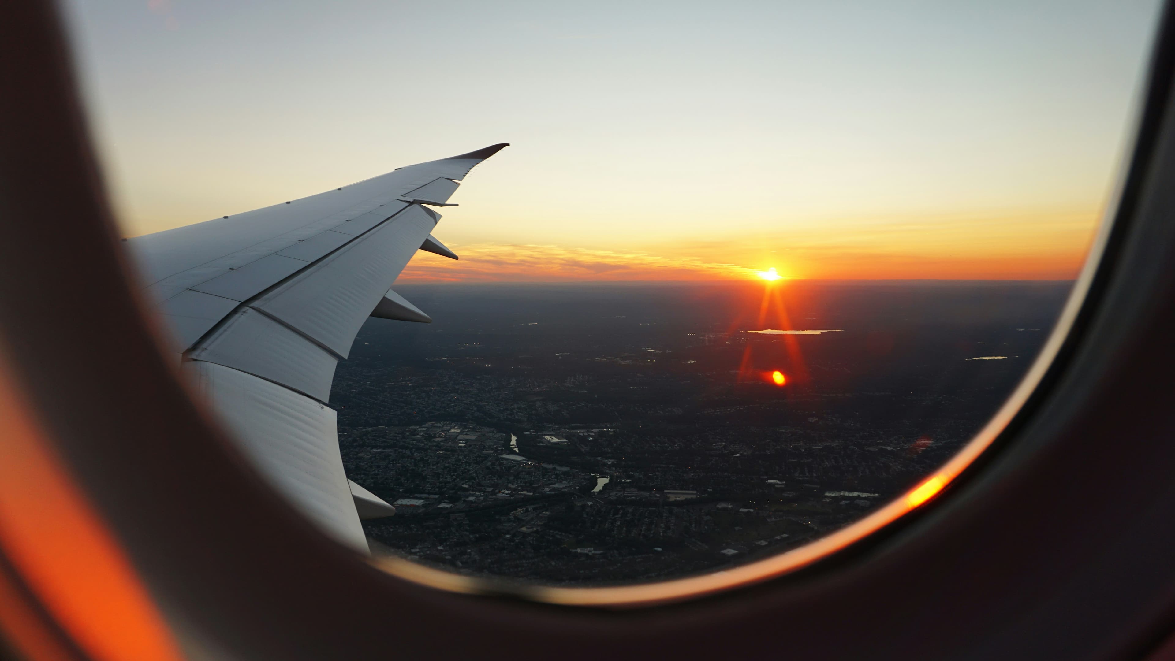 Sunset over a city seen from an aircraft window